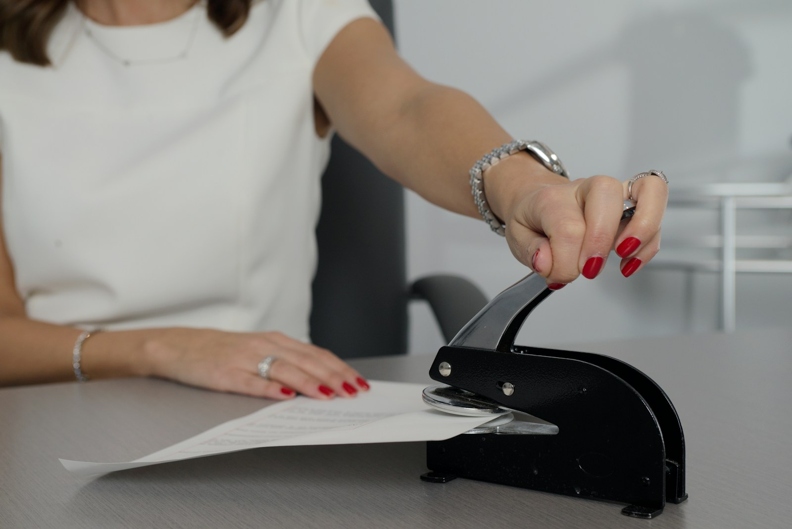 A notary pressing an embossing seal onto a signed document